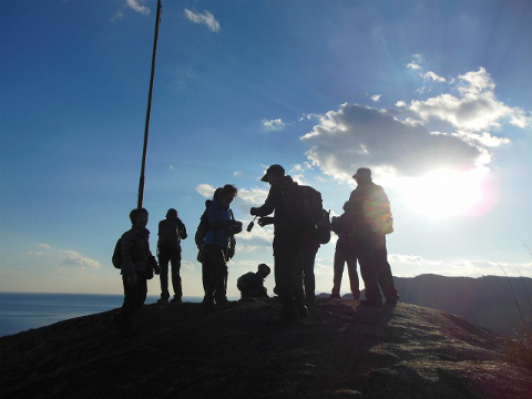 熊野市の華城山に立つガイドとツアー参加者