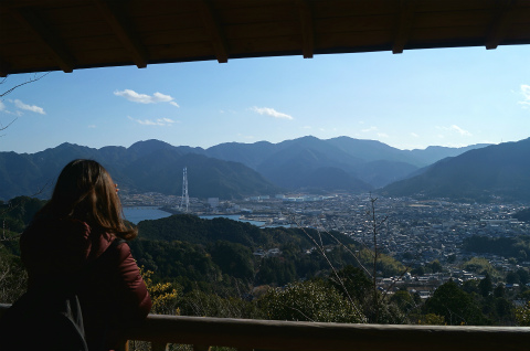 熊野古道伊勢路・馬越公園の展望東屋から尾鷲市を眺めるツアー参加女性