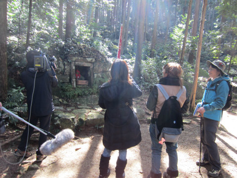 熊野古道の夜泣き地蔵でガイド内山裕紀子とツアー参加女性とテレビ撮影クルー