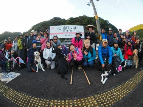 団体・法人様プラン、二木島駅にてガイドと犬連れ参加者の集合写真